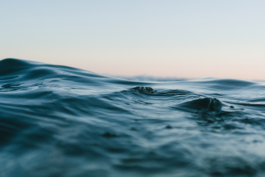 A detailed close-up of the ocean's surface, its deep grey-blue hues evoking a sense of refreshing hydration.