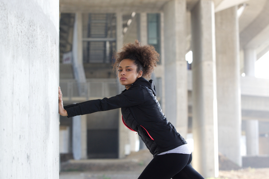  Woman in Workout Attire Stretching Arms by Placing Them on Wall.