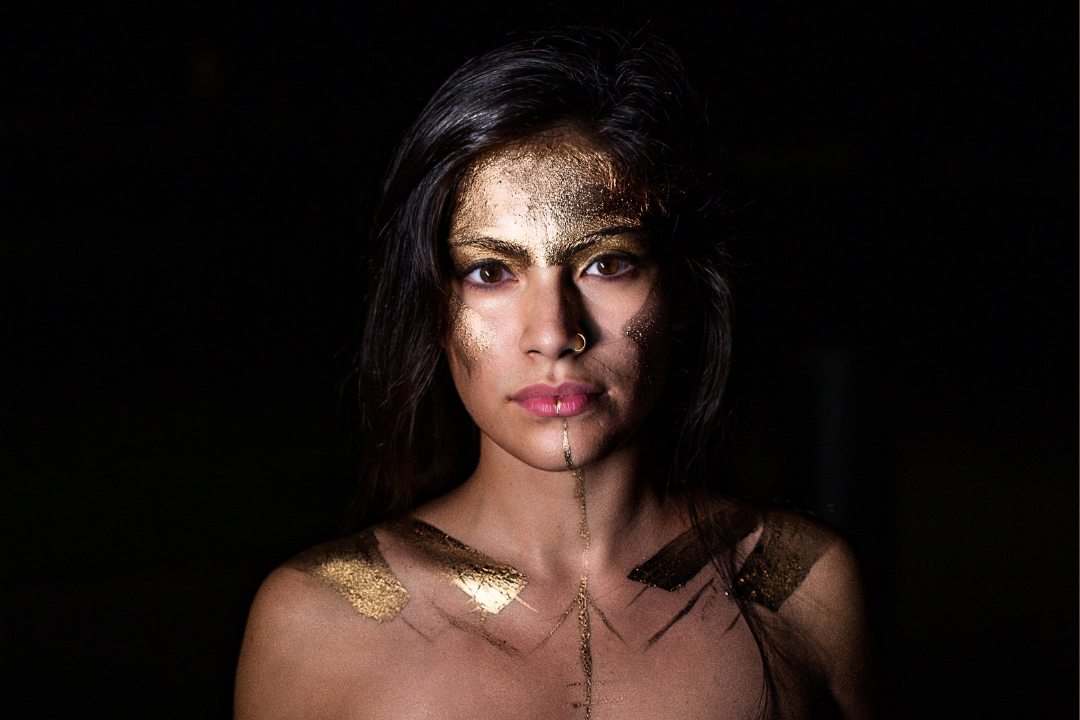  Captivating Woman Gazing Forward with Adorned Gold Foil on Her Face.