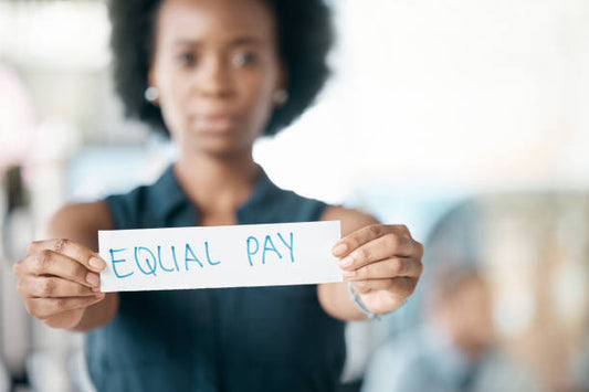 Woman Holding a White Paper Slip Saying 'EQUAL PAY'.
